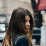 woman holding brown leather bag in bokeh photography